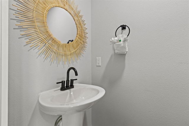 bathroom with a textured wall and a sink