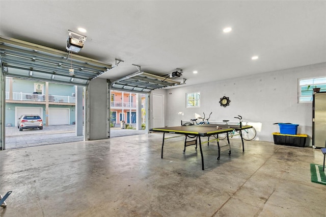 recreation room featuring a garage, recessed lighting, and concrete flooring