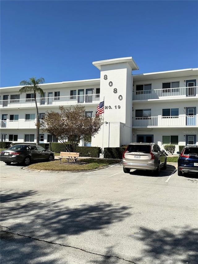 view of building exterior with uncovered parking