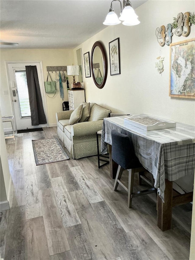 dining room with a notable chandelier, baseboards, and wood finished floors