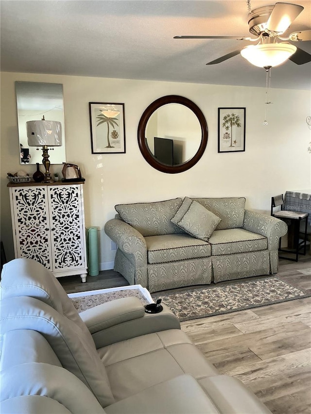 living room featuring a ceiling fan and wood finished floors