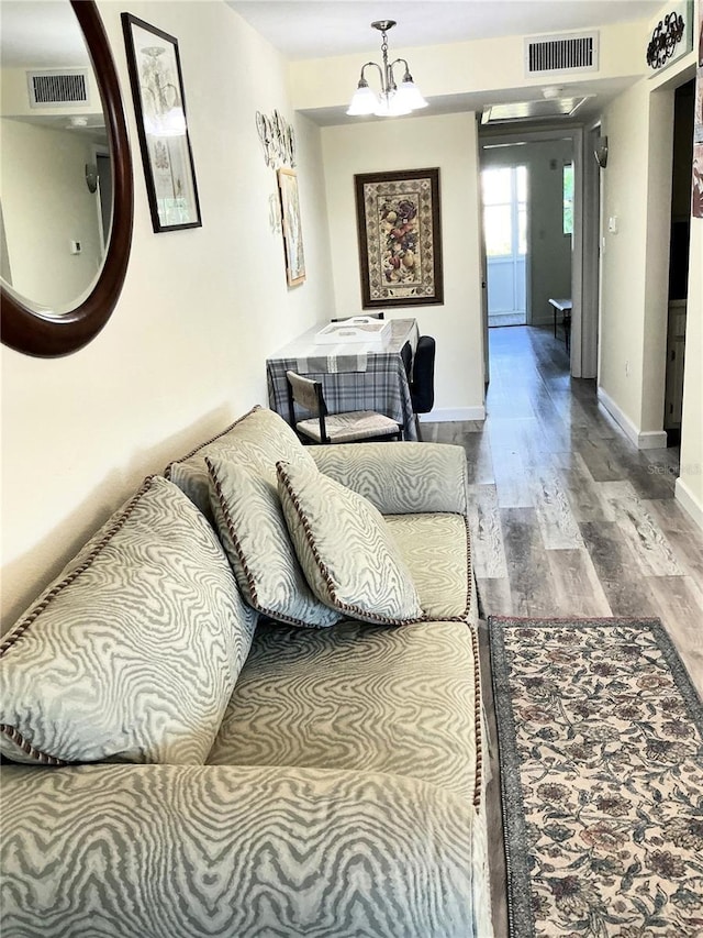 living area with visible vents, baseboards, and wood finished floors