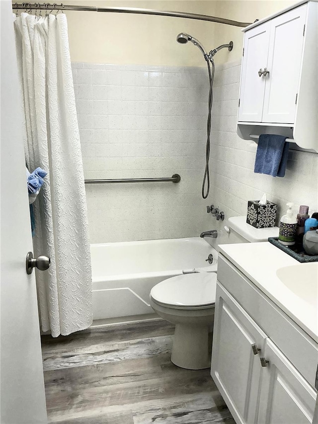 bathroom with vanity, toilet, shower / tub combo with curtain, and wood finished floors