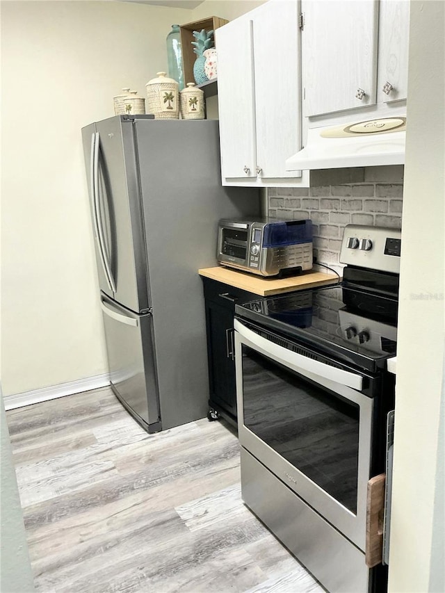 8080 112th St Unit 206, Seminole, FL 33772 - kitchen featuring light countertops, under cabinet range hood, stainless steel appliances, light wood-style floors, and decorative backsplash