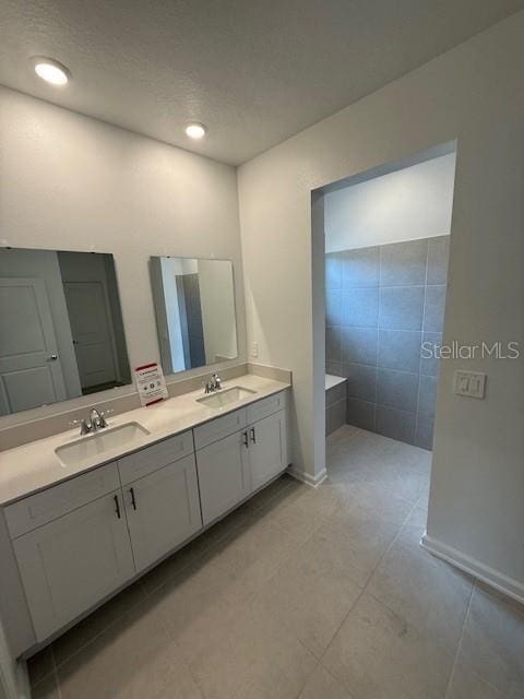 full bathroom featuring recessed lighting, a sink, baseboards, and double vanity