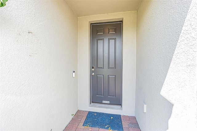 entrance to property with stucco siding