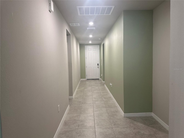 hallway featuring light tile patterned flooring, baseboards, and visible vents