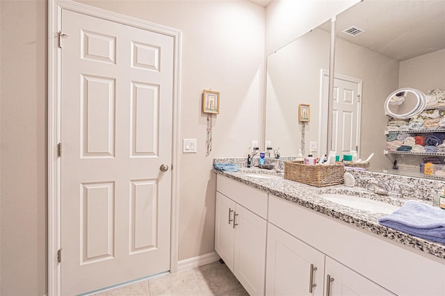 bathroom featuring a sink, visible vents, double vanity, and tile patterned floors