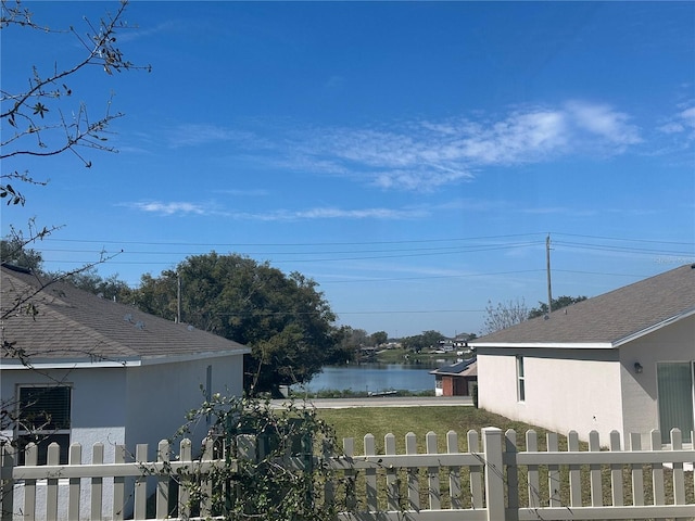 exterior space featuring a water view and a fenced front yard