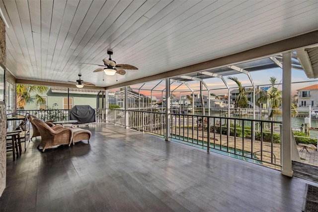 sunroom / solarium featuring plenty of natural light, wooden ceiling, and a ceiling fan