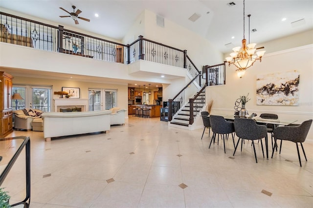 foyer entrance with recessed lighting, ceiling fan with notable chandelier, a fireplace, visible vents, and stairs