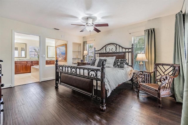 bedroom featuring dark wood-style floors, baseboards, visible vents, and ensuite bathroom