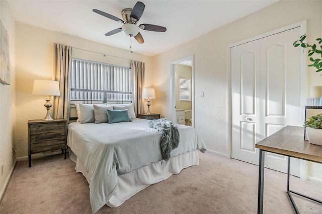 bedroom featuring a ceiling fan, light colored carpet, and a textured wall