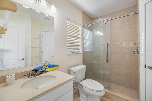 full bathroom with toilet, a shower stall, and vanity