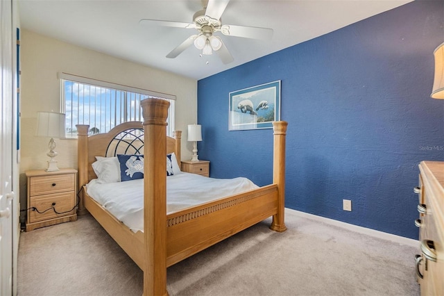 carpeted bedroom with baseboards, a ceiling fan, and a textured wall