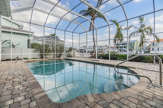 pool with a patio area, a residential view, and glass enclosure