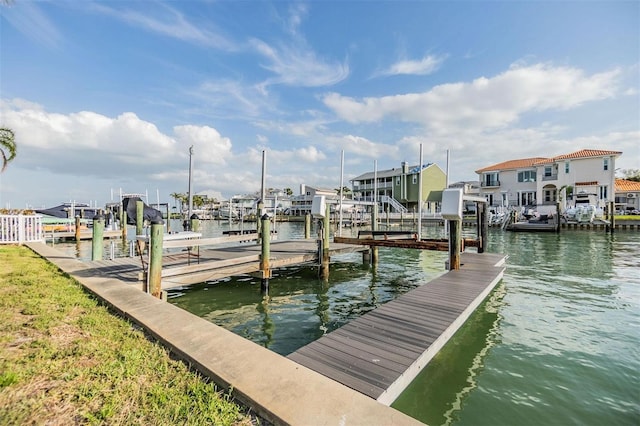 view of dock featuring a water view, boat lift, and a residential view