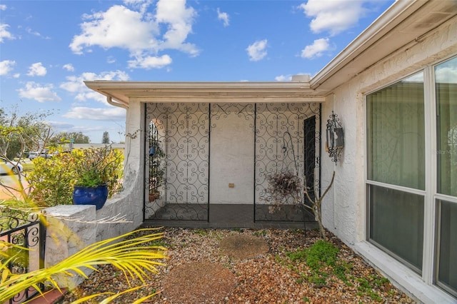 entrance to property featuring stucco siding