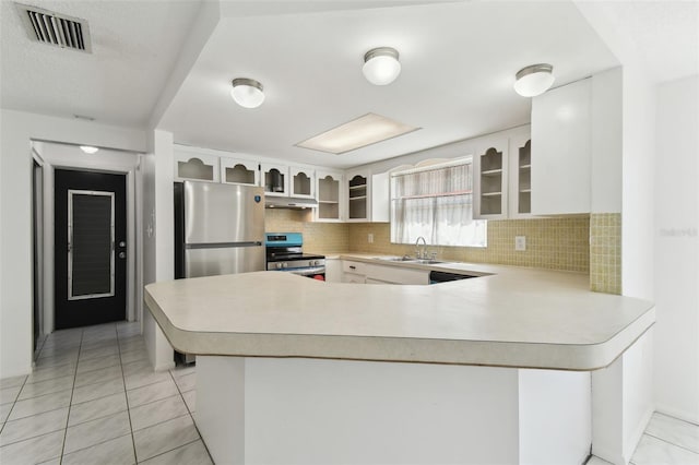 kitchen featuring visible vents, appliances with stainless steel finishes, a peninsula, under cabinet range hood, and a sink