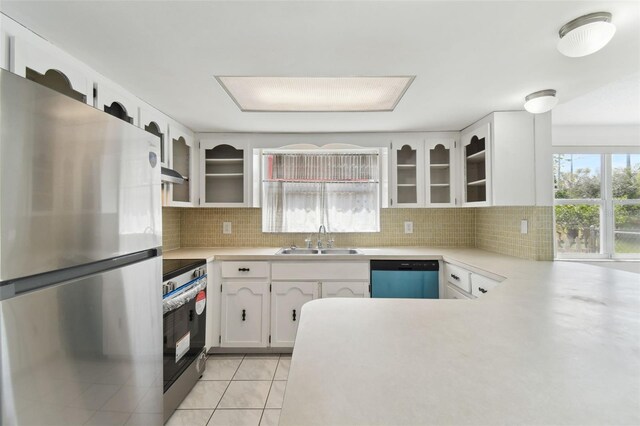 kitchen featuring stainless steel appliances, tasteful backsplash, a sink, and light countertops