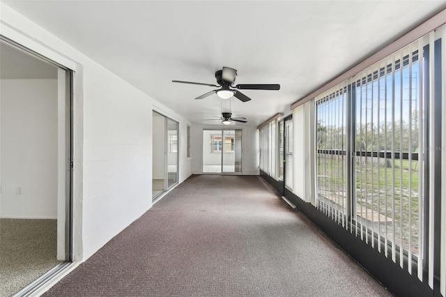 unfurnished sunroom with ceiling fan