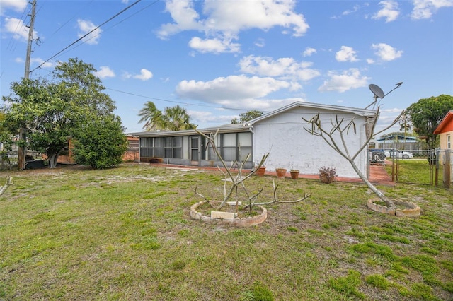 back of property featuring a gate, a sunroom, a lawn, and fence