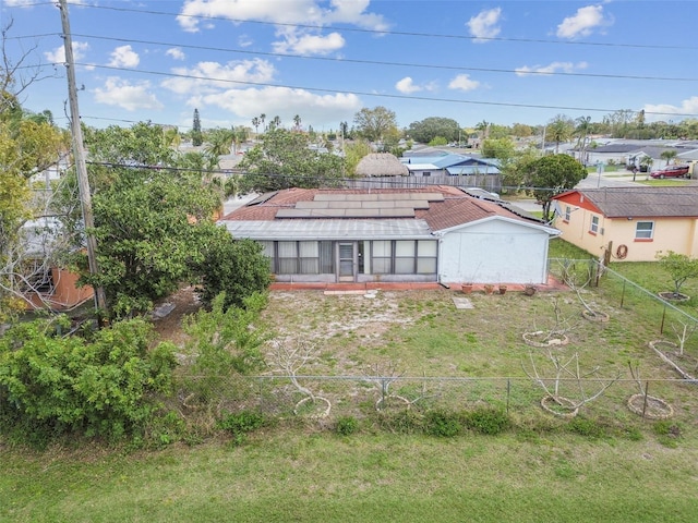 exterior space with a yard, solar panels, and fence private yard