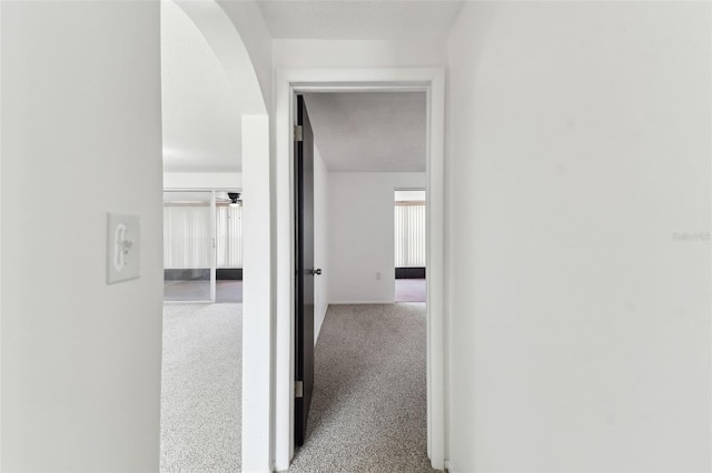 hall featuring carpet and arched walkways