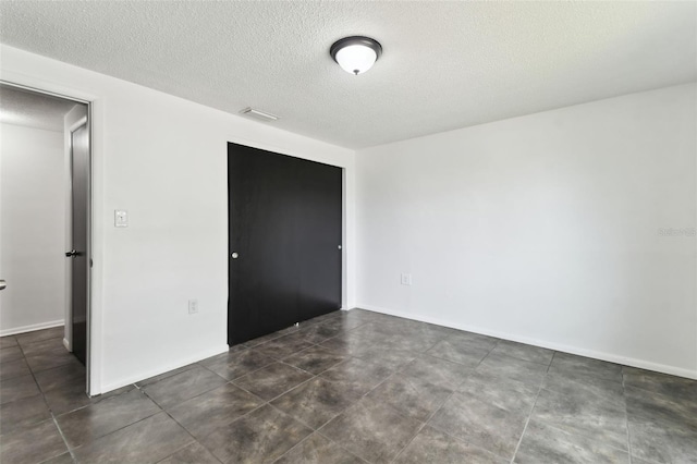 interior space with baseboards, visible vents, and a textured ceiling