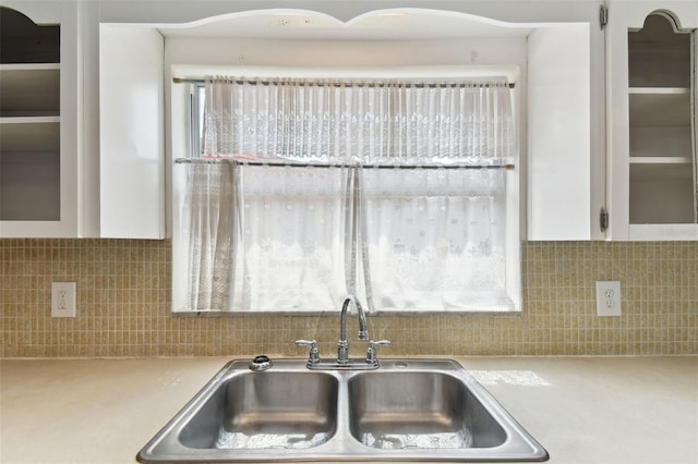 kitchen featuring light countertops, white cabinetry, a sink, and decorative backsplash