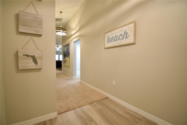 hallway with wood finished floors and baseboards