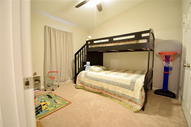 carpeted bedroom with vaulted ceiling and a ceiling fan