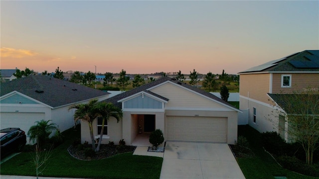 ranch-style house with a garage, driveway, and a front lawn