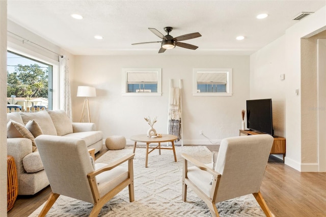 living area featuring recessed lighting, a ceiling fan, visible vents, baseboards, and light wood-type flooring
