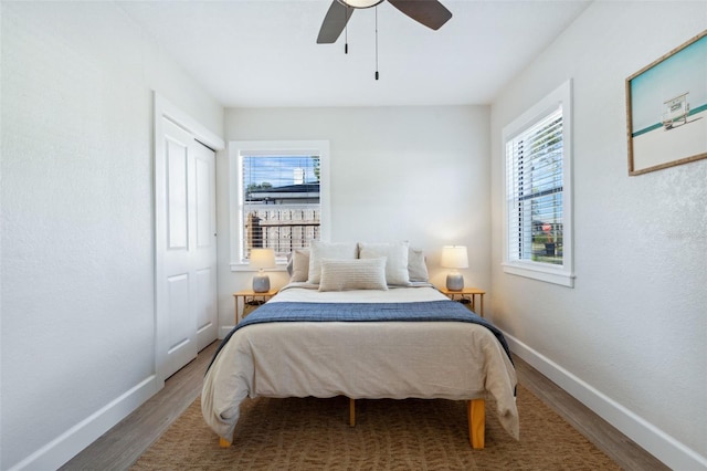 bedroom featuring ceiling fan, baseboards, and wood finished floors