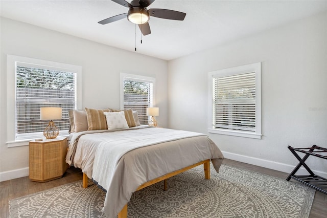 bedroom featuring a ceiling fan, baseboards, and wood finished floors