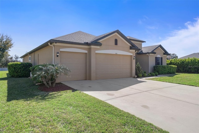 ranch-style house featuring a garage, a front yard, concrete driveway, and stucco siding