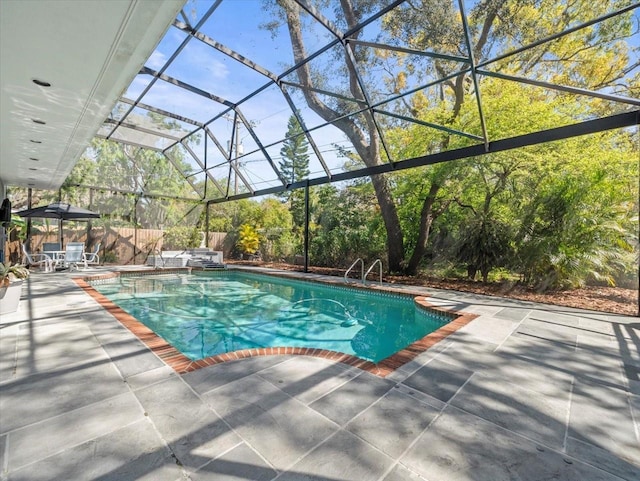 view of swimming pool with glass enclosure, a patio area, fence, and a fenced in pool