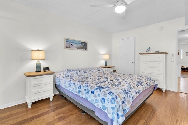 bedroom featuring ceiling fan, baseboards, and wood finished floors