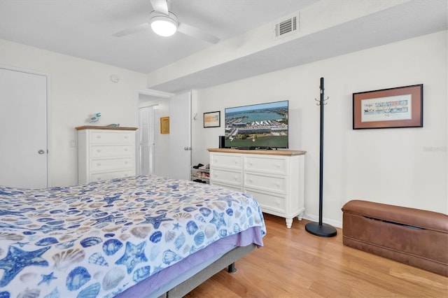 bedroom featuring baseboards, light wood-style flooring, visible vents, and a ceiling fan