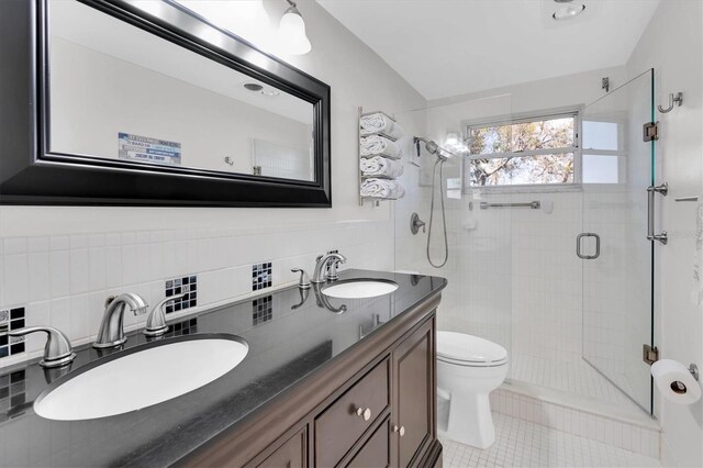 full bath featuring a shower stall, tile walls, a sink, and tile patterned floors