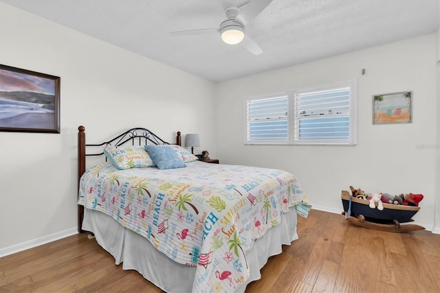 bedroom featuring ceiling fan, baseboards, and wood finished floors