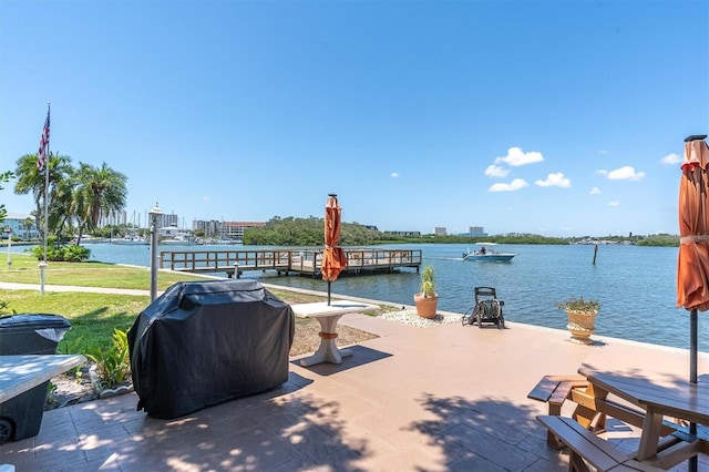 view of patio / terrace with a city view, grilling area, and a water view