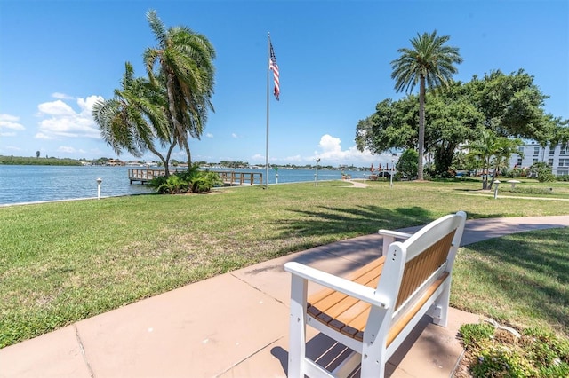 view of property's community with a lawn and a water view