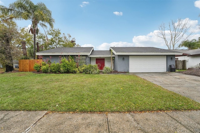 ranch-style home with fence, concrete driveway, a front yard, stucco siding, and an attached garage