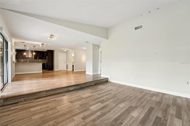 unfurnished living room featuring light wood-style flooring, baseboards, and visible vents