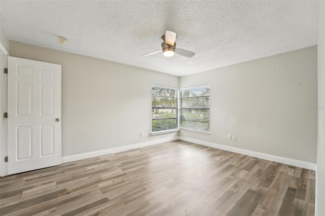 spare room with baseboards, a ceiling fan, and wood finished floors