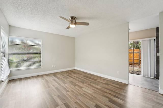 unfurnished room with baseboards, wood finished floors, a textured ceiling, and ceiling fan