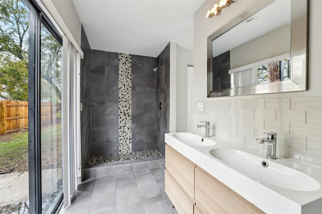 bathroom featuring a sink, backsplash, and a tile shower