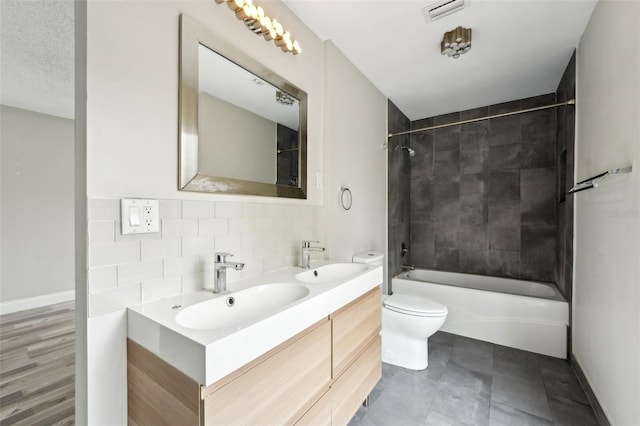 bathroom with tasteful backsplash, visible vents, toilet, and a sink